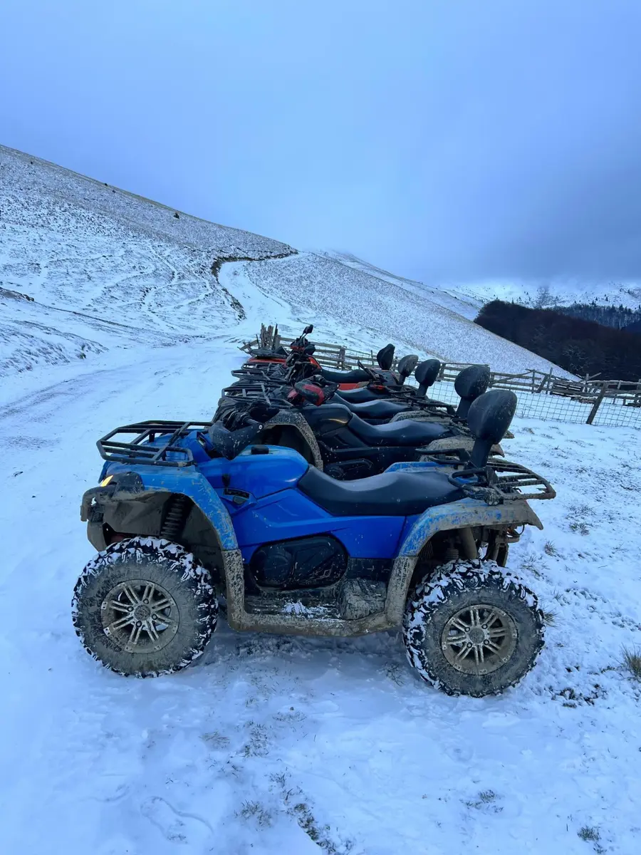 ATV CFMoto albastru fotografiat pe zăpadă