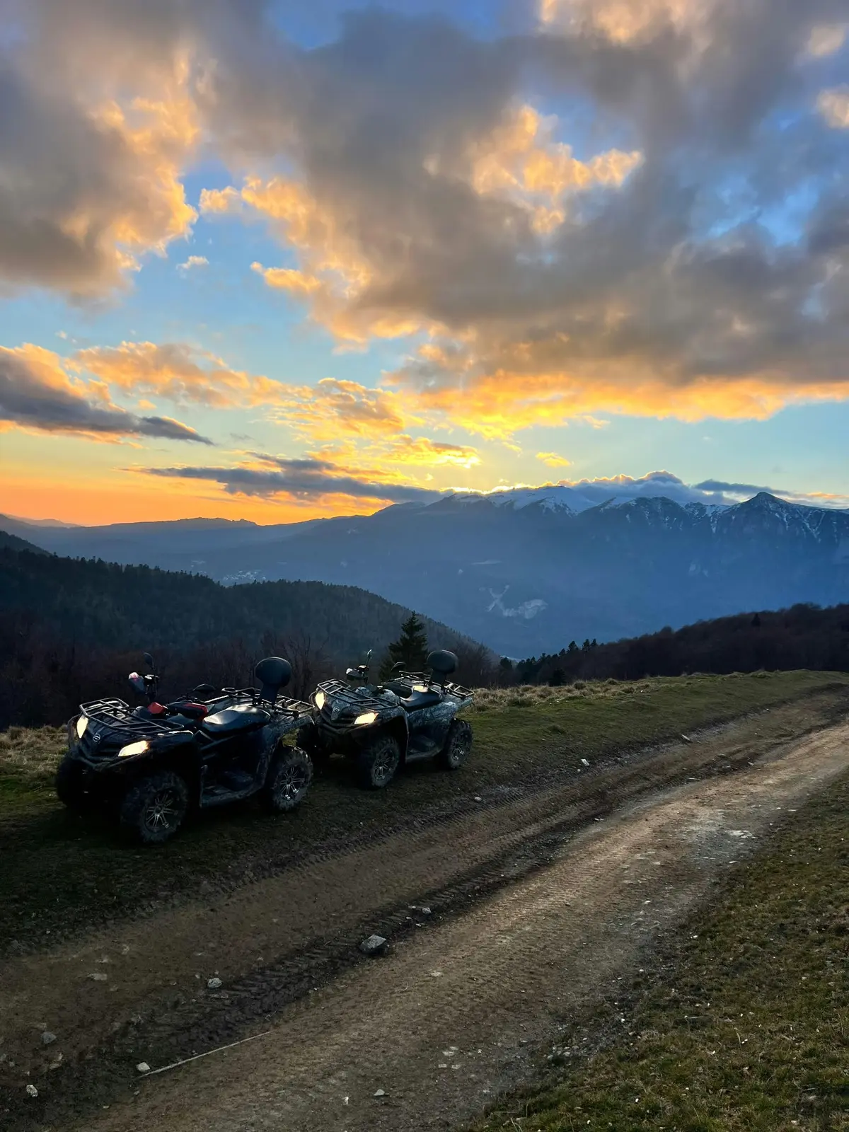 ATV-uri CFMoto pe traseu la apus, cu Munții Baiului în fundal