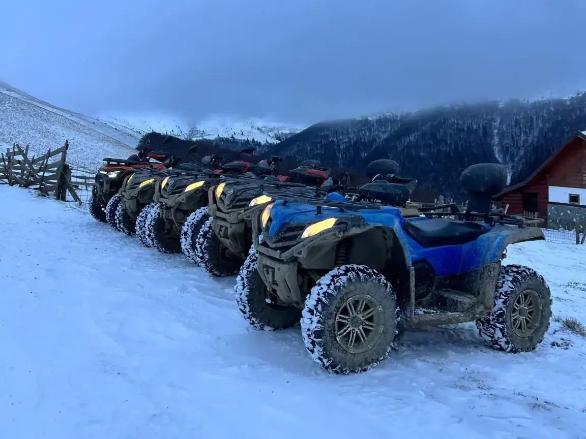 Flota reală de ATV-uri CFMoto 450 L aliniată pe zăpadă în Bușteni