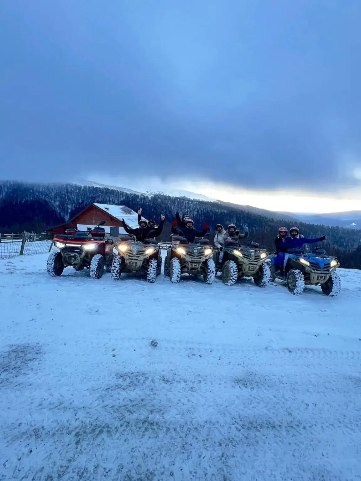 Grup de turiști alături de flota CFMoto pe zăpadă în Bușteni