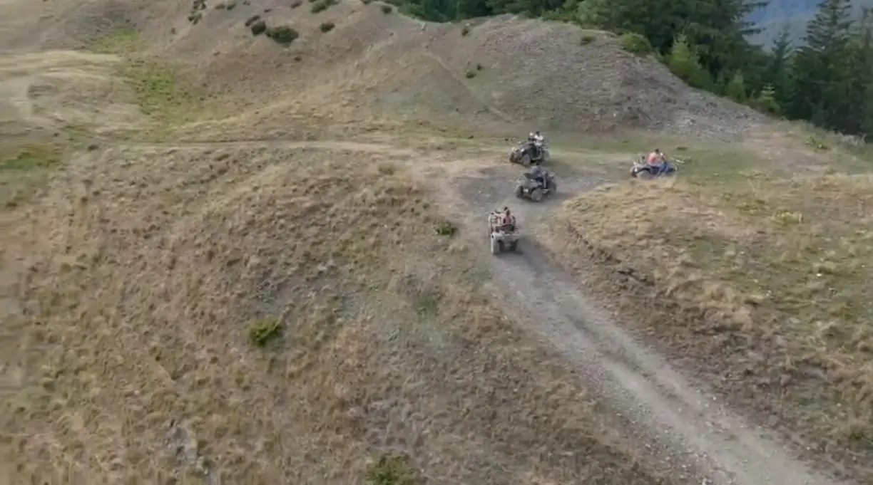 Grup de ATV-uri pe traseu montan văzut din dronă în apropiere de Bușteni